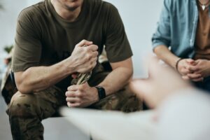 veteran in group therapy twisting hat